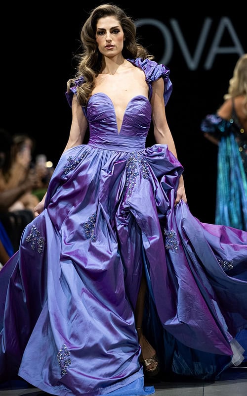 Model wearing Jovani S39133 purple gown with deep V-neck and voluminous skirt