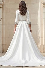 Back view of a long sleeve A-line wedding gown with beaded belt and crystal cuff details.