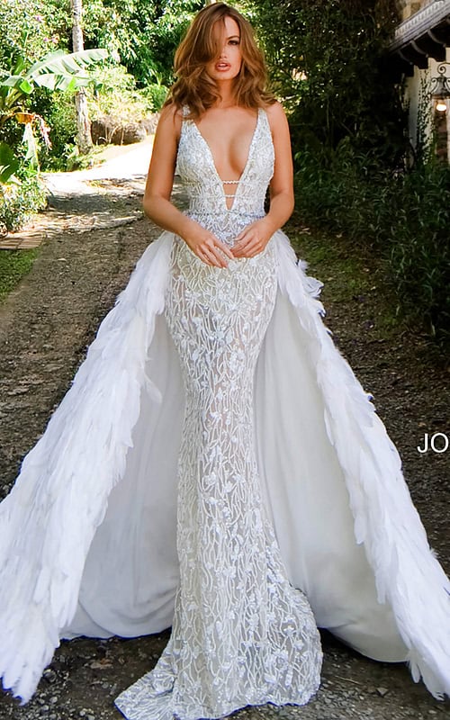 Model wearing Jovani S62942 white gown with mermaid silhouette and feather overlay.