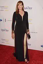 Model wearing Jovani 27006 black dress with deep V-neckline and high slit, front view.