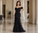 black off-shoulder mermaid gown with feather skirt in luxury interior
