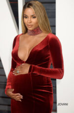 Close-up of model in Jovani S55169 burgundy velvet gown with deep V-neckline.