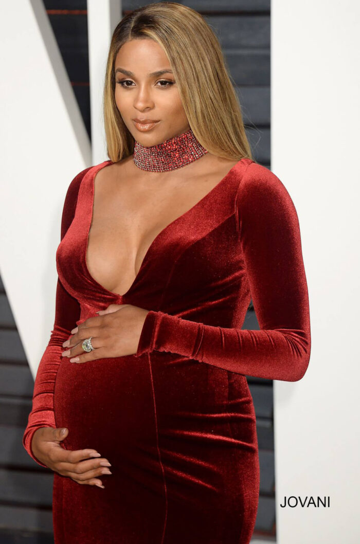 Close-up of model in Jovani S55169 burgundy velvet gown with deep V-neckline.