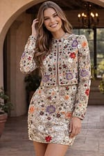 Two-piece champagne ensemble featuring a cropped long-sleeve jacket and a high-waisted mini skirt with all-over floral embroidery and sequins.