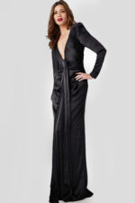 Model wearing Jovani 23180 elegant black gown with deep V-neckline and knot detail, angled front view.