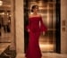 Elegant woman entering luxury gala wearing red gown
