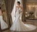 Bride in strapless ivory mermaid lace wedding dress in bridal boutique mirror setting