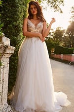 Model wearing Jovani jb05781, an ivory gown with a plunging neckline and embroidery.