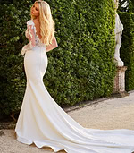Model showcasing the back of Jovani JB07632 ivory mermaid gown with low V-back design.
