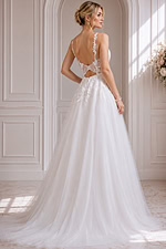 Soft bridal silhouette featuring a lace bodice, flowing skirt, and open-back detail.