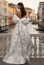 Back view of brocade wedding gown with oversized bow and flowing train