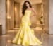 Young woman in strapless yellow floral gown in luxurious modern interior