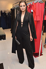 Model wearing Jovani 40470 black jumpsuit with a chic overcoat.