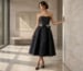 Strapless black bow midi dress, luxury editorial scene