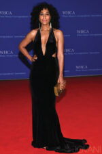 Model wearing Jovani 40454 black gown with a halter neckline and side cut-outs.
